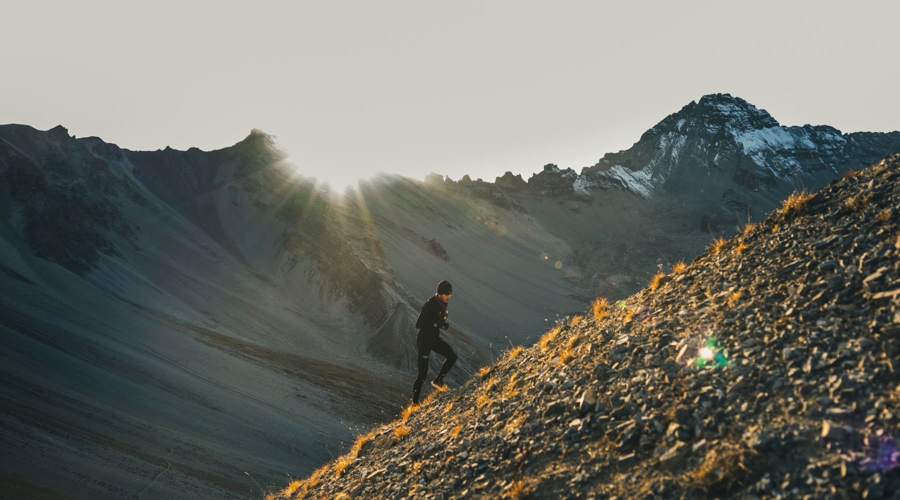 homme qui court dans les montagnes au levé du soleil