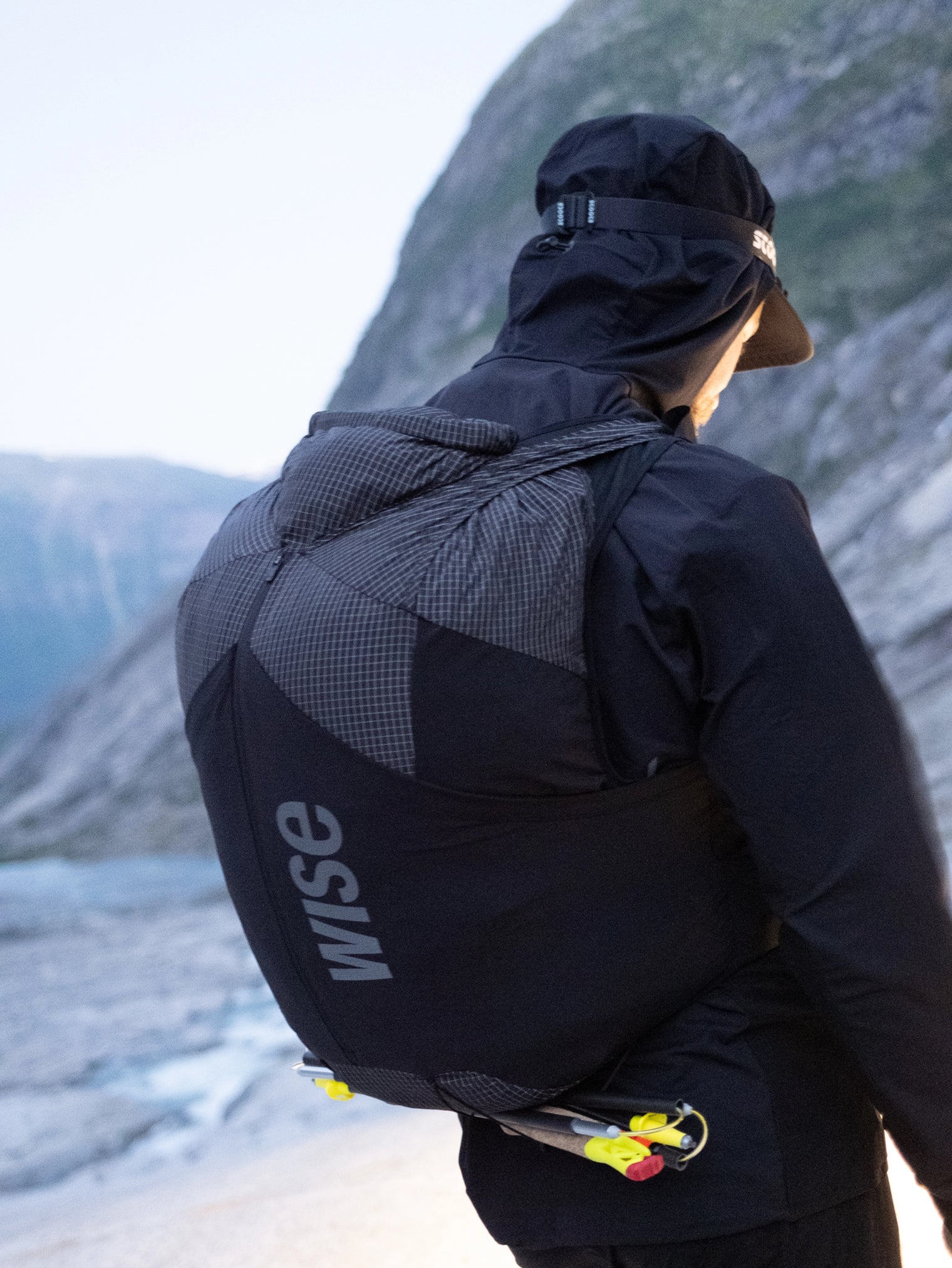 Homme portant un sac itinérance WISE et batons de trail
